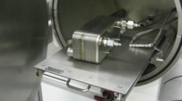 Open door view of leak test vacuum chamber with internal stainless steel slide-out shelf and test part